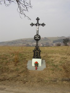 osazený zrekonstruovaný kříž v krajině